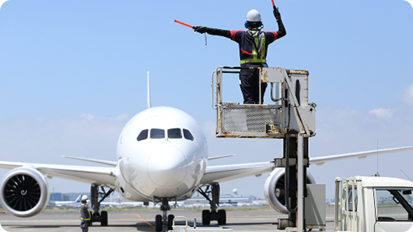 Ground handling staff marshalling the airplane.