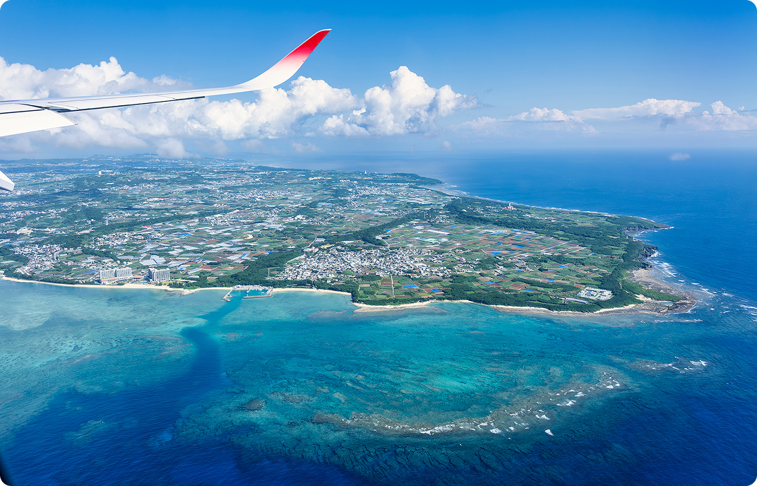 An island and the wing of airplane seen from the airplane.