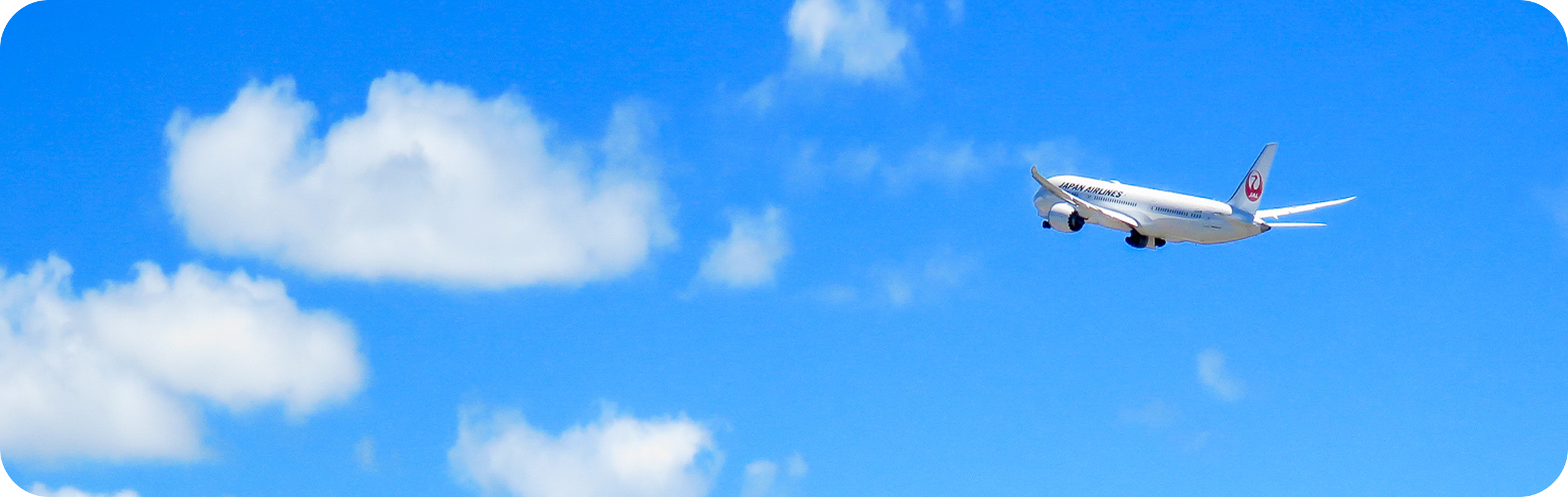 An airplane flying high in the blue sky.