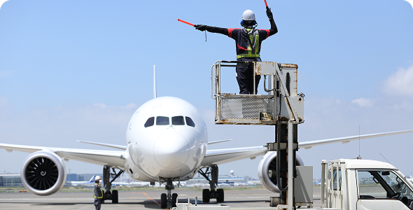 Ground handling staff marshalling the airplane.