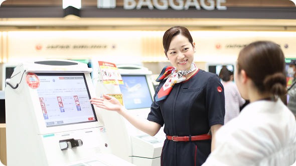 自動チェックイン機の案内をする旅客スタッフ