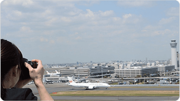 飛行機の写真を撮る女性