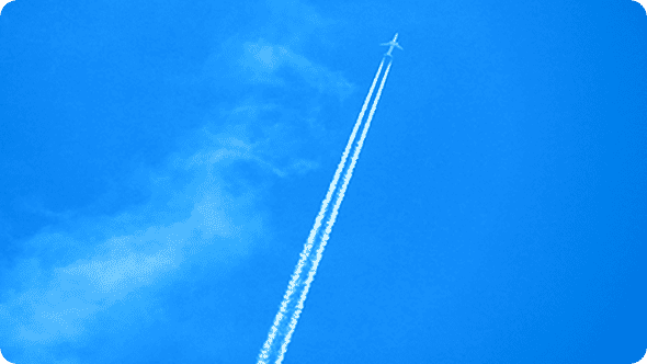 青空を飛行する飛行機と白い飛行機雲