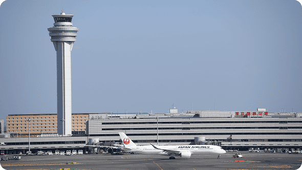 管制塔と空港ターミナルを背景にした飛行機