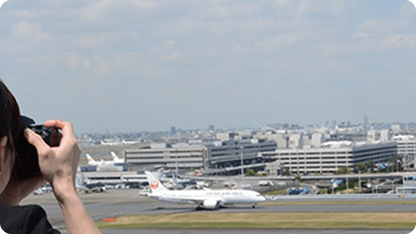 飛行機の写真を撮る女性