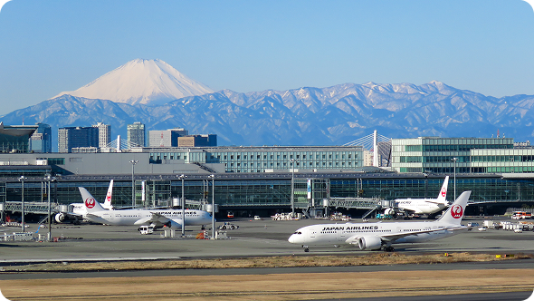 滑走路に止まる飛行機と富士山