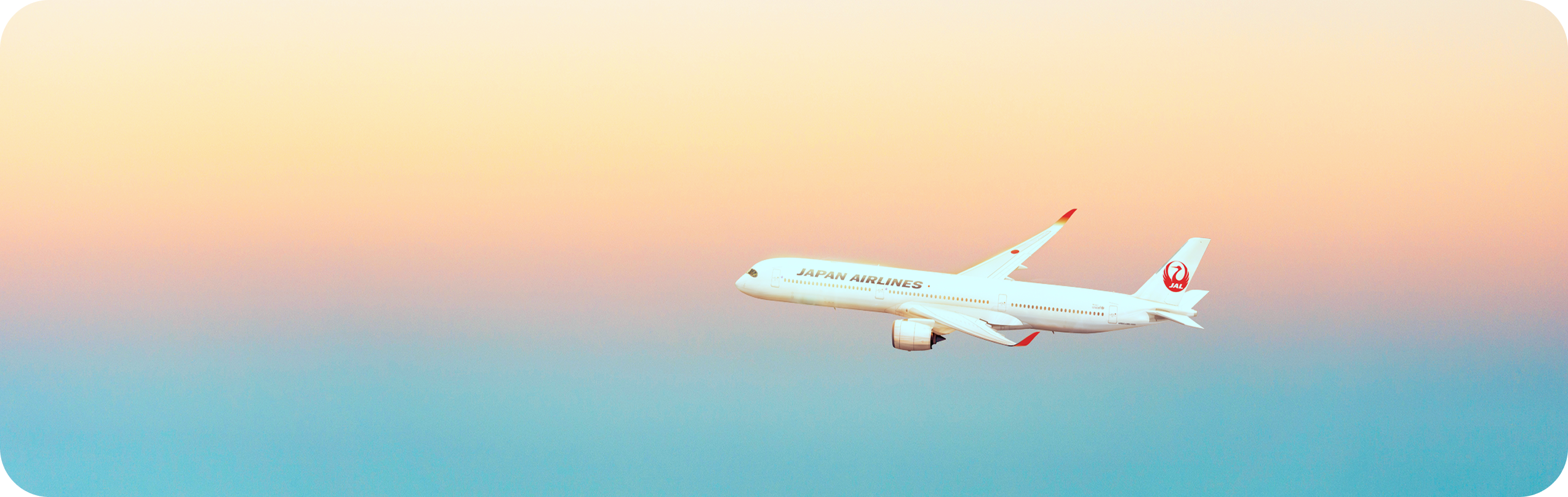 夕焼けの空を背景に、上空を飛行する飛行機