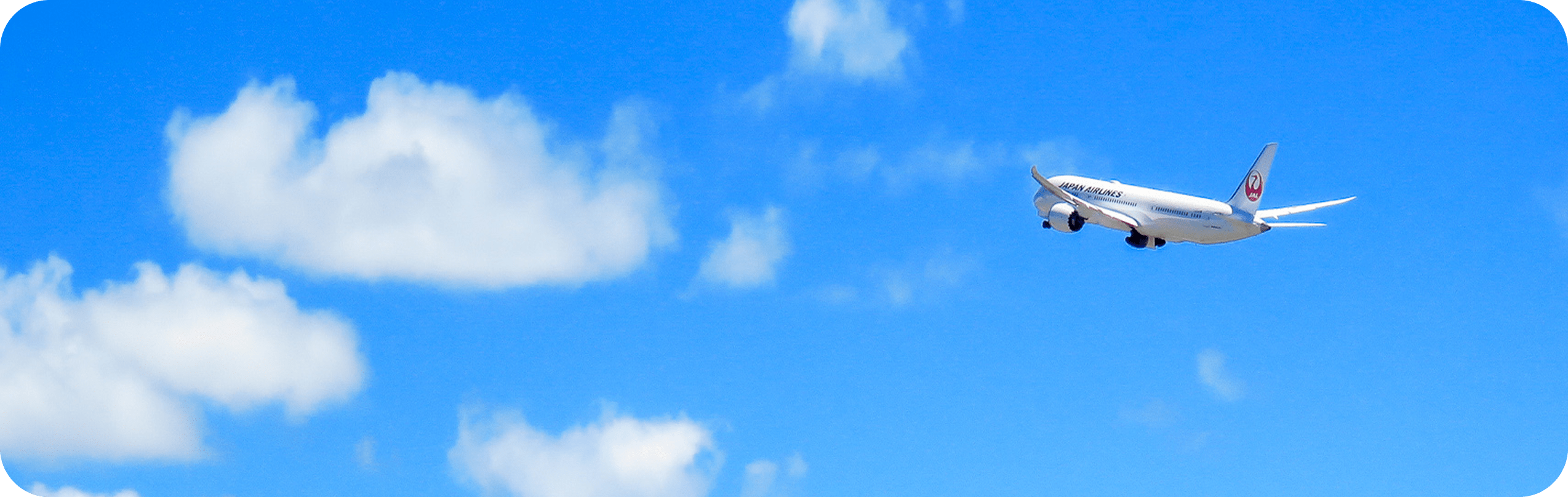 青空を高く飛んでいく飛行機